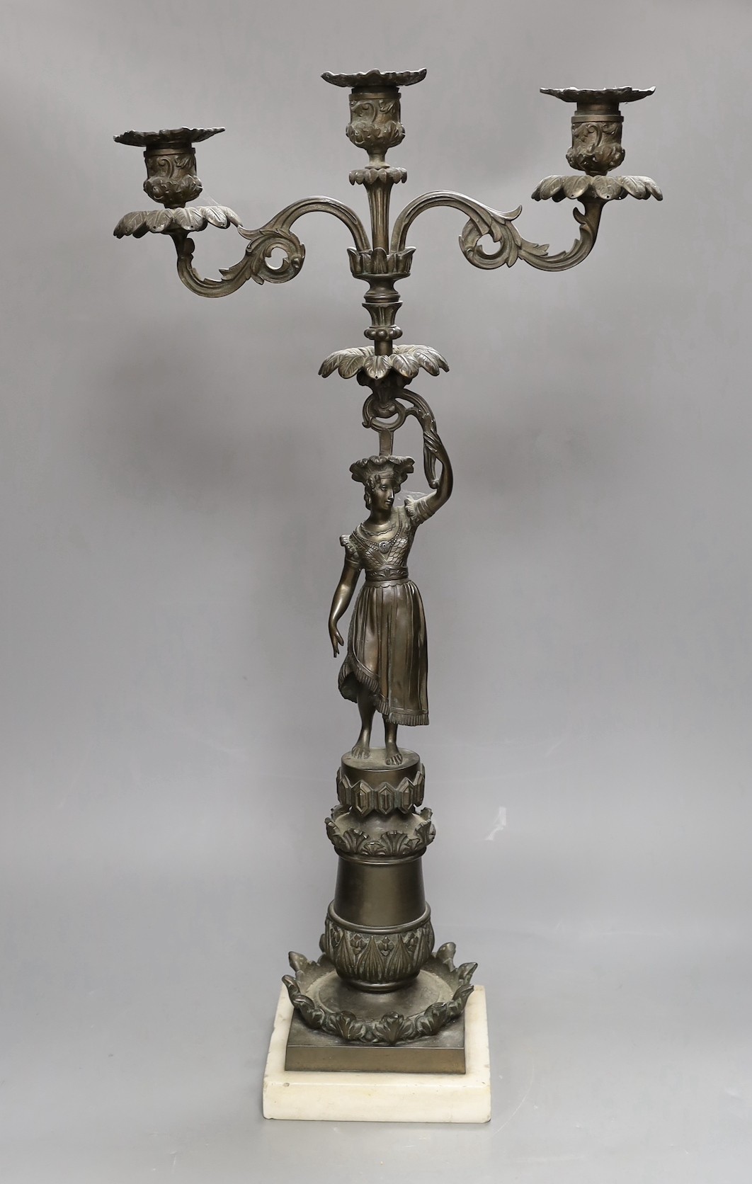 A bronzed spelter figural three light candelabrum, 60cms high